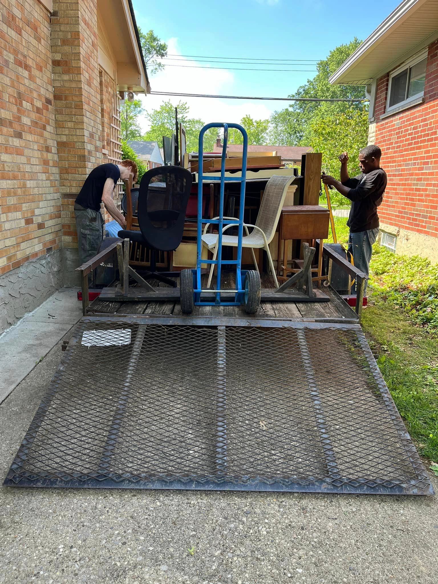 Do Good Cleanouts team loading a truck at a residential property